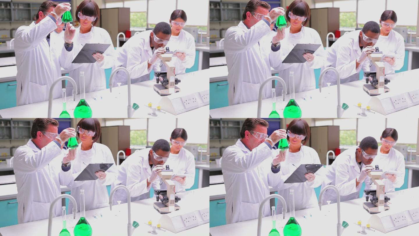 学生使用平板电脑和显微镜在实验室进行研究