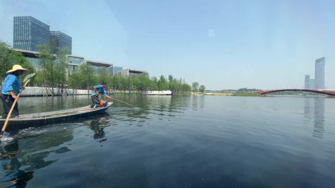 城市公园环卫工人划船水面清理杂物杂草