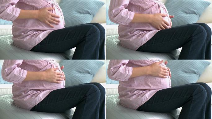 孕妇坐在沙发上摸肚子特写
