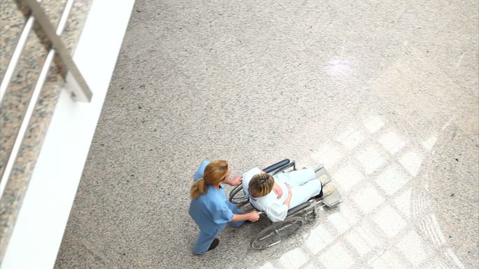 医疗团队用轮椅推着女人在医院里特写