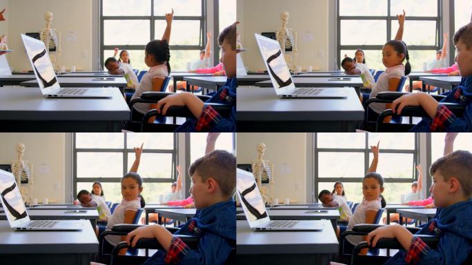 小学生坐在书桌前举手