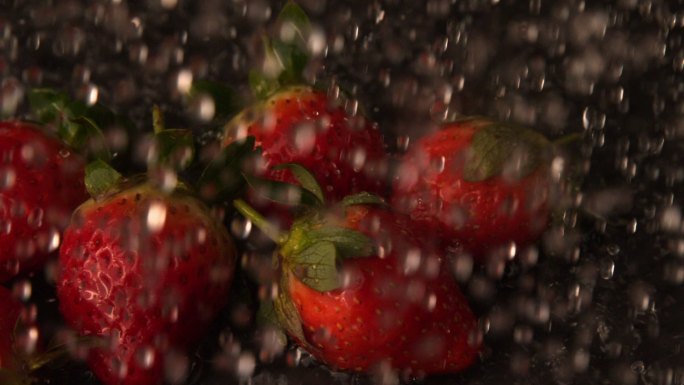 慢镜头中，水倒在一篮草莓上