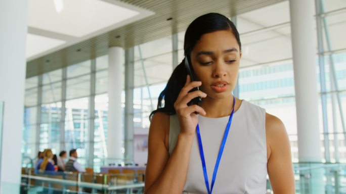 年轻漂亮的非裔美国女商人在办公室里用移动电话讲4k