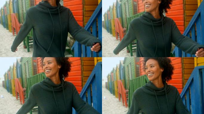 一个年轻的非裔美国女人走在4k海滩小屋旁