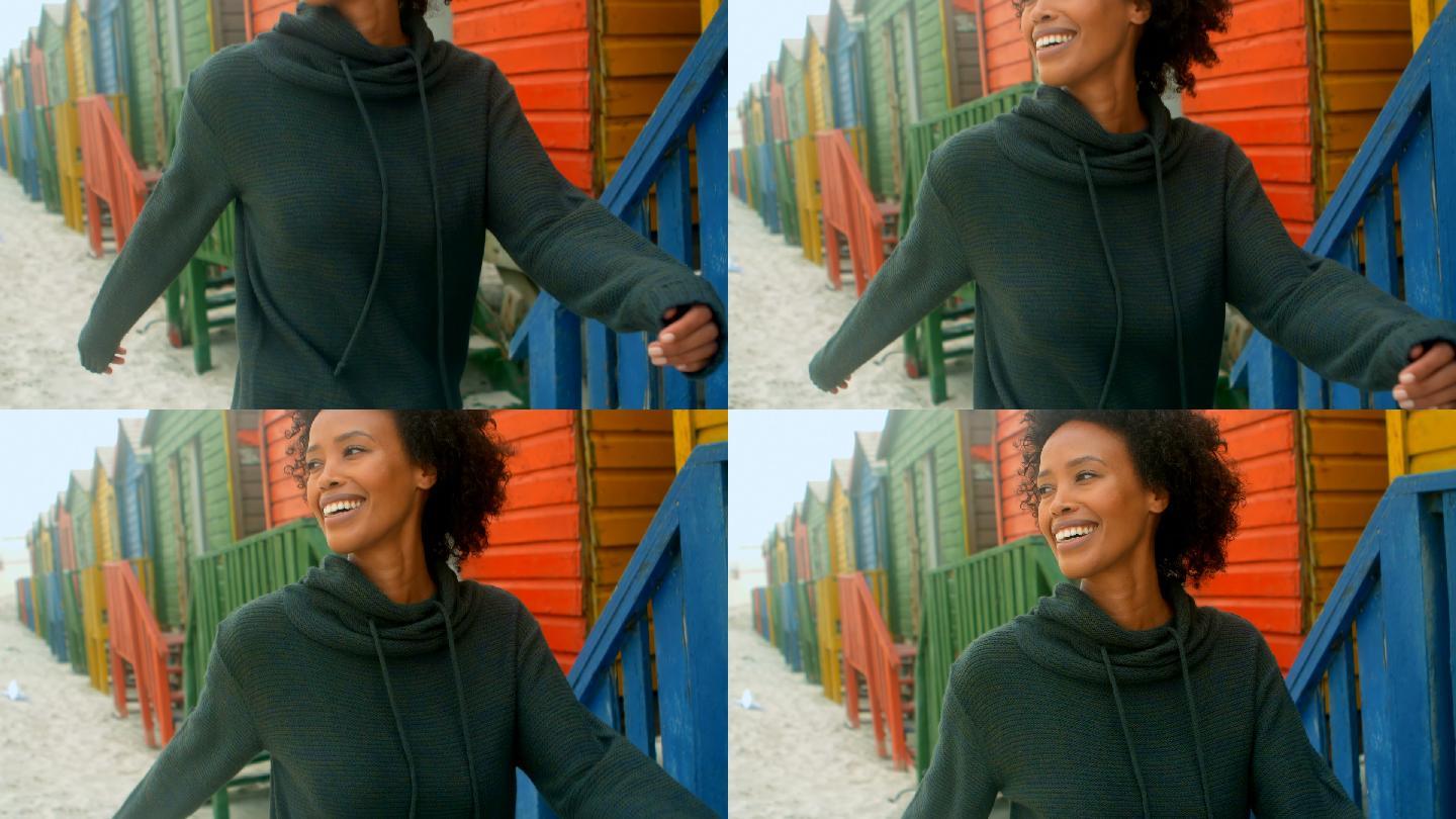 一个年轻的非裔美国女人走在4k海滩小屋旁