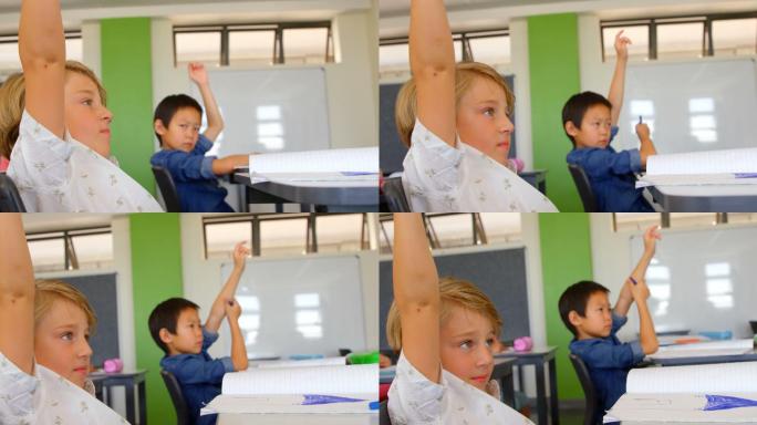 多民族学校的男孩在教室里举手