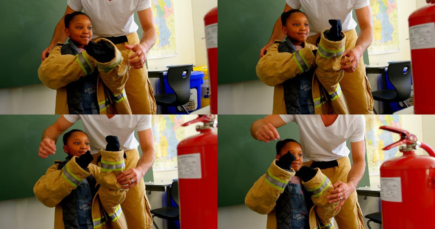 男消防员帮助非裔美国女孩在教室穿消防制服。女孩微笑