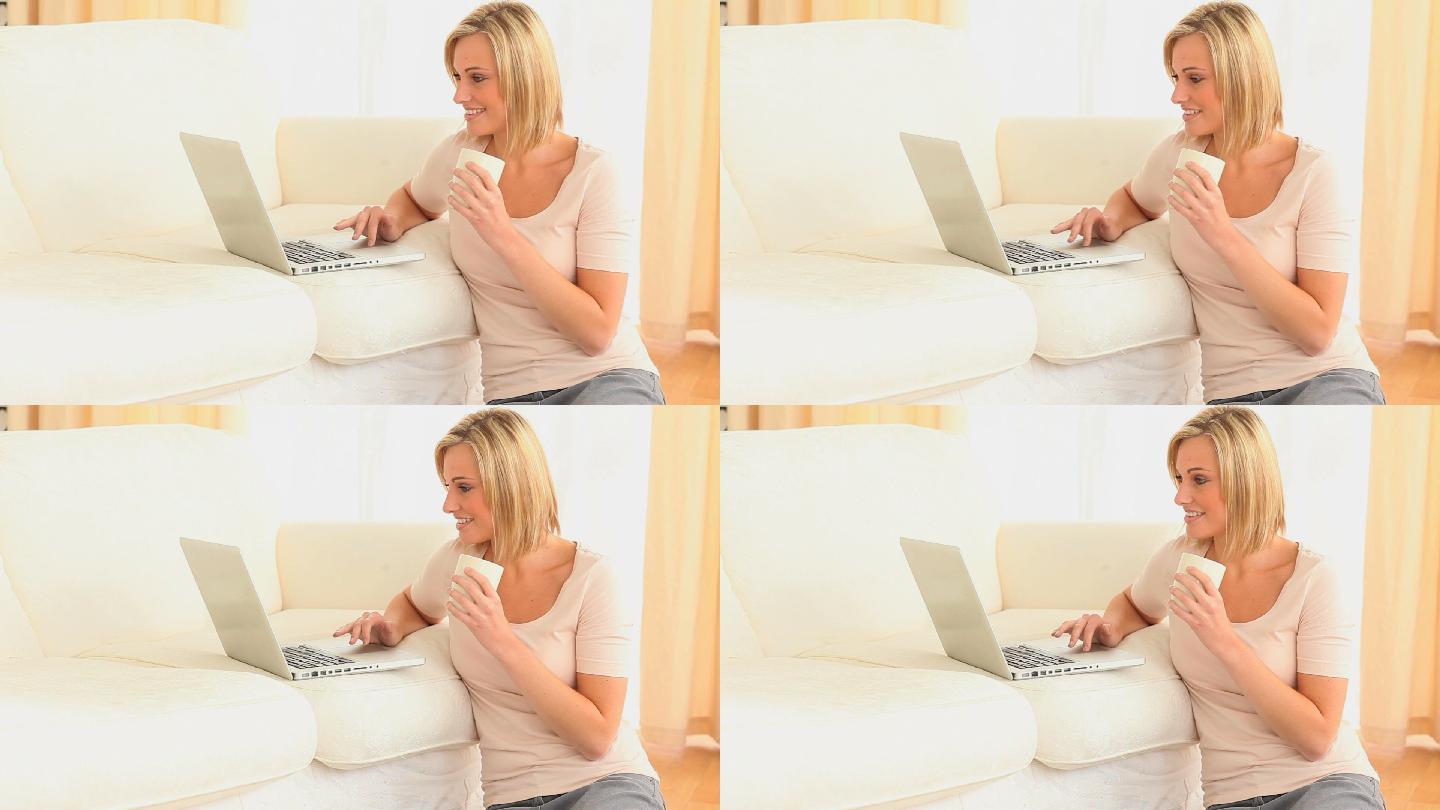 一个女人一边喝茶一边看电脑特写