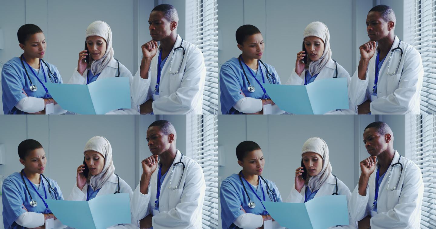 正面视图中东女医生与她的同事在医院用手机交谈