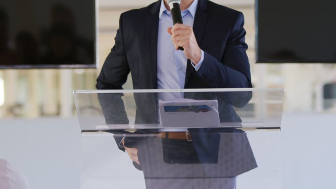 一位男性演讲者在商业会议上向听众讲话