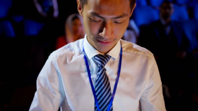 在4k大礼堂，年轻的亚洲商人在商务研讨会上使用数码平板电脑