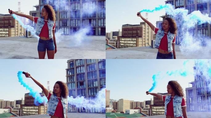 时尚的年轻女子在城市的屋顶上使用烟雾弹