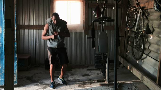 年轻的非裔美国男拳击手在健身室练习4k拳击