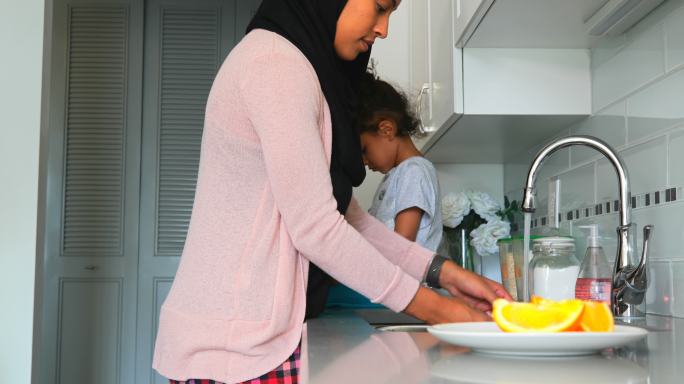 年轻的母亲在厨房洗碗在家4k