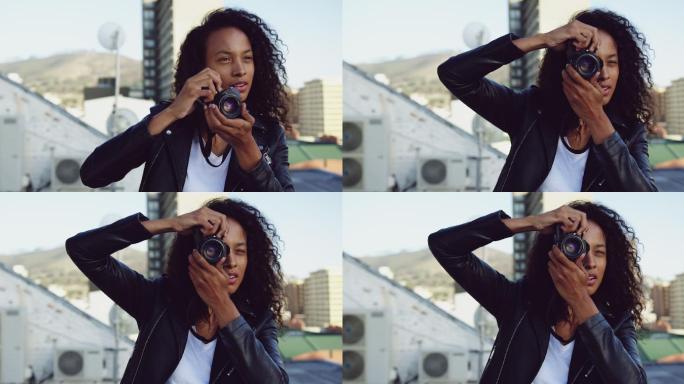 时尚的年轻女子在城市的屋顶上拍照