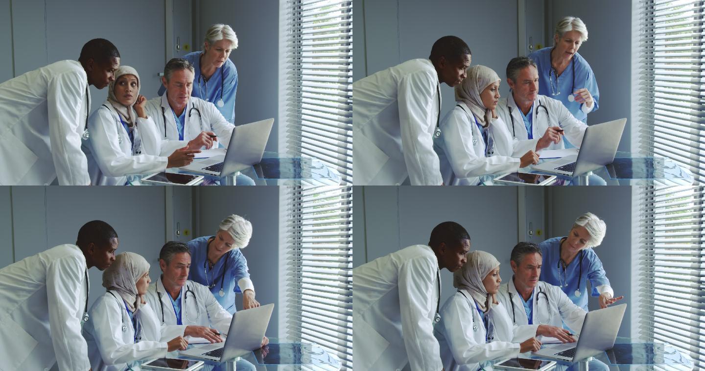 多民族医生在医院通过笔记本电脑讨论正面视图