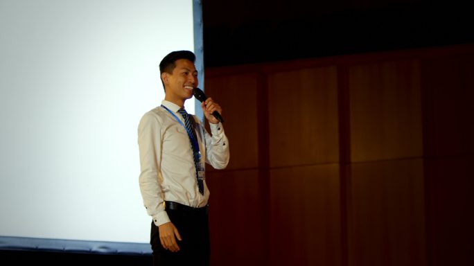 年轻的亚洲商人在4k大礼堂的商业研讨会上发言