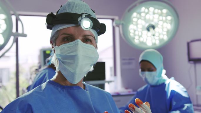 特写白种女外科医生站在手术室在医院
