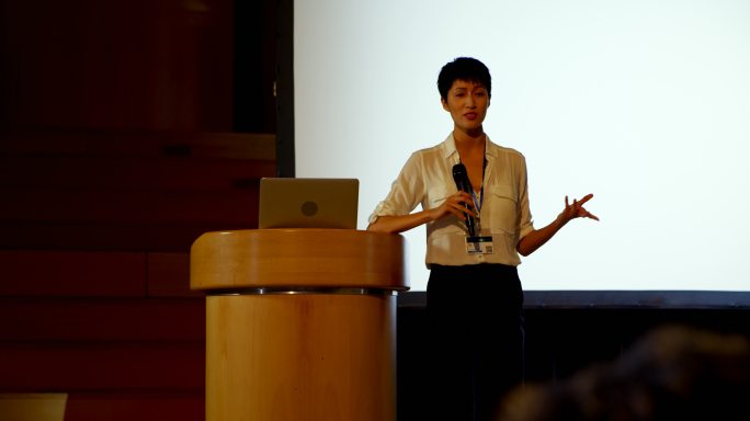 在4k大礼堂的商业研讨会上，年轻的亚洲女商人在演讲