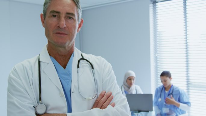白人男医生站在医院双臂交叉的特写