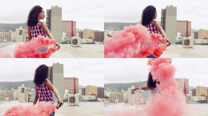 时尚的年轻女子在城市的屋顶上使用烟雾弹