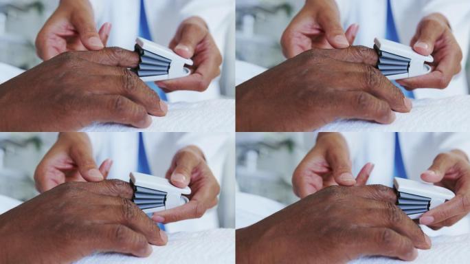 特写的非洲裔美国女医生附加脉搏血氧仪在男病人的手在病房