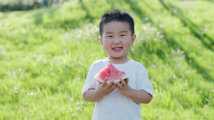 4K夏天草坪上阳光下可爱的孩子吃西瓜