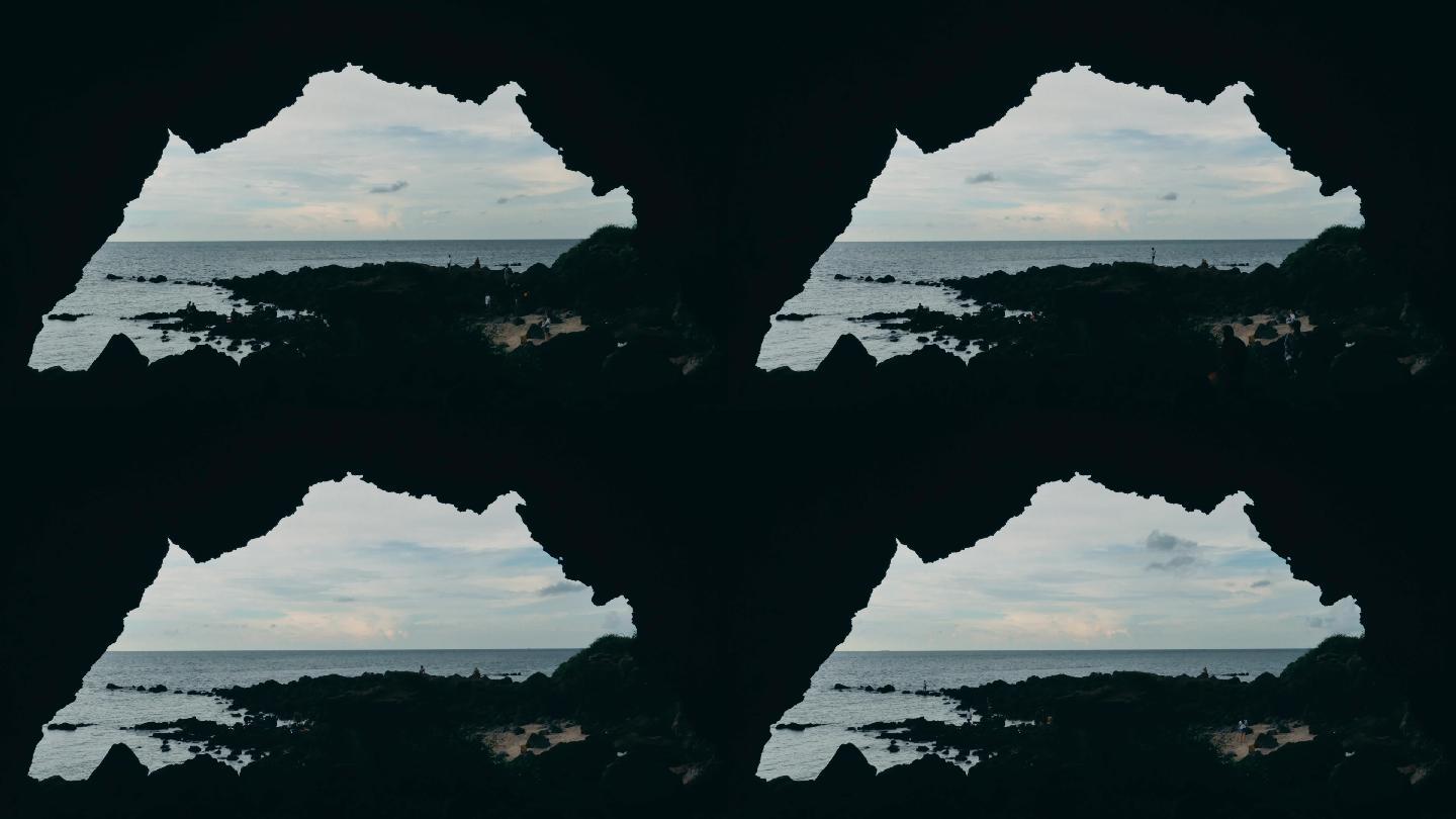 游客在苍穹岩石下的海边游玩儋州龙门激浪