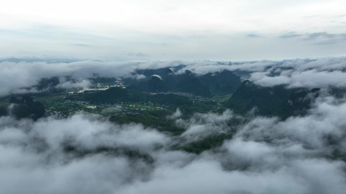 雨雾缭绕下喀斯特地貌山谷中的田园风光