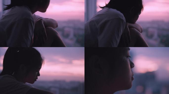 女孩在夕阳下的落地窗边想心事4k视频素材