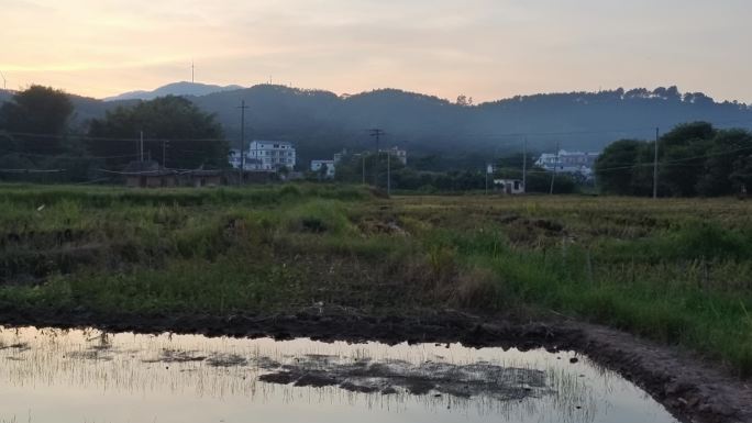 乡村傍晚炊烟田间晚霞农民劳作远山剪影