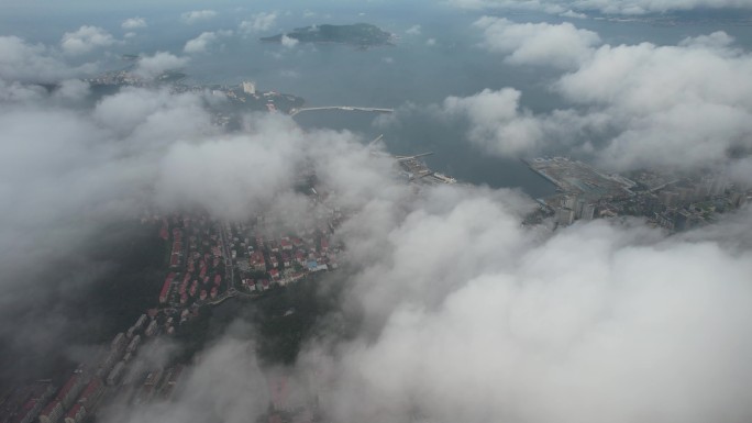 航拍飞云之下的威海湾和城市街区