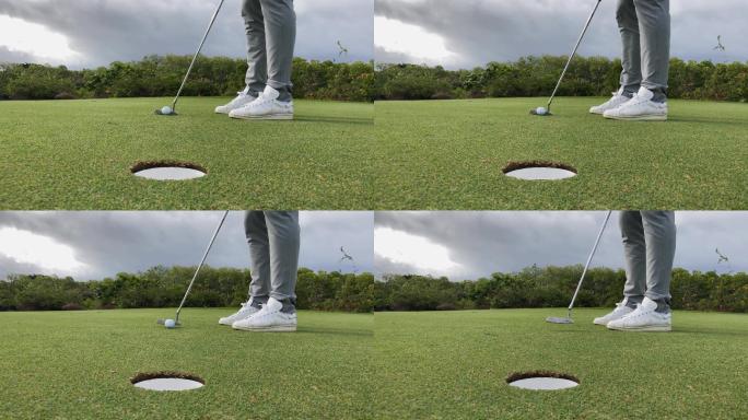 高尔夫运动员在果岭上推杆入球洞的局部特写