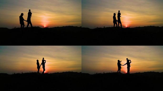 幸福的一家人，一家三口山顶散步看夕阳晚霞