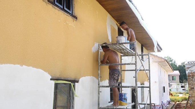 刷墙工人粉刷外墙