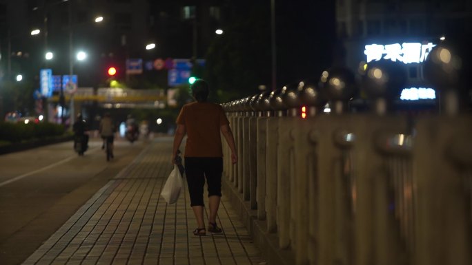 老人孤独的走在路上城市夜景