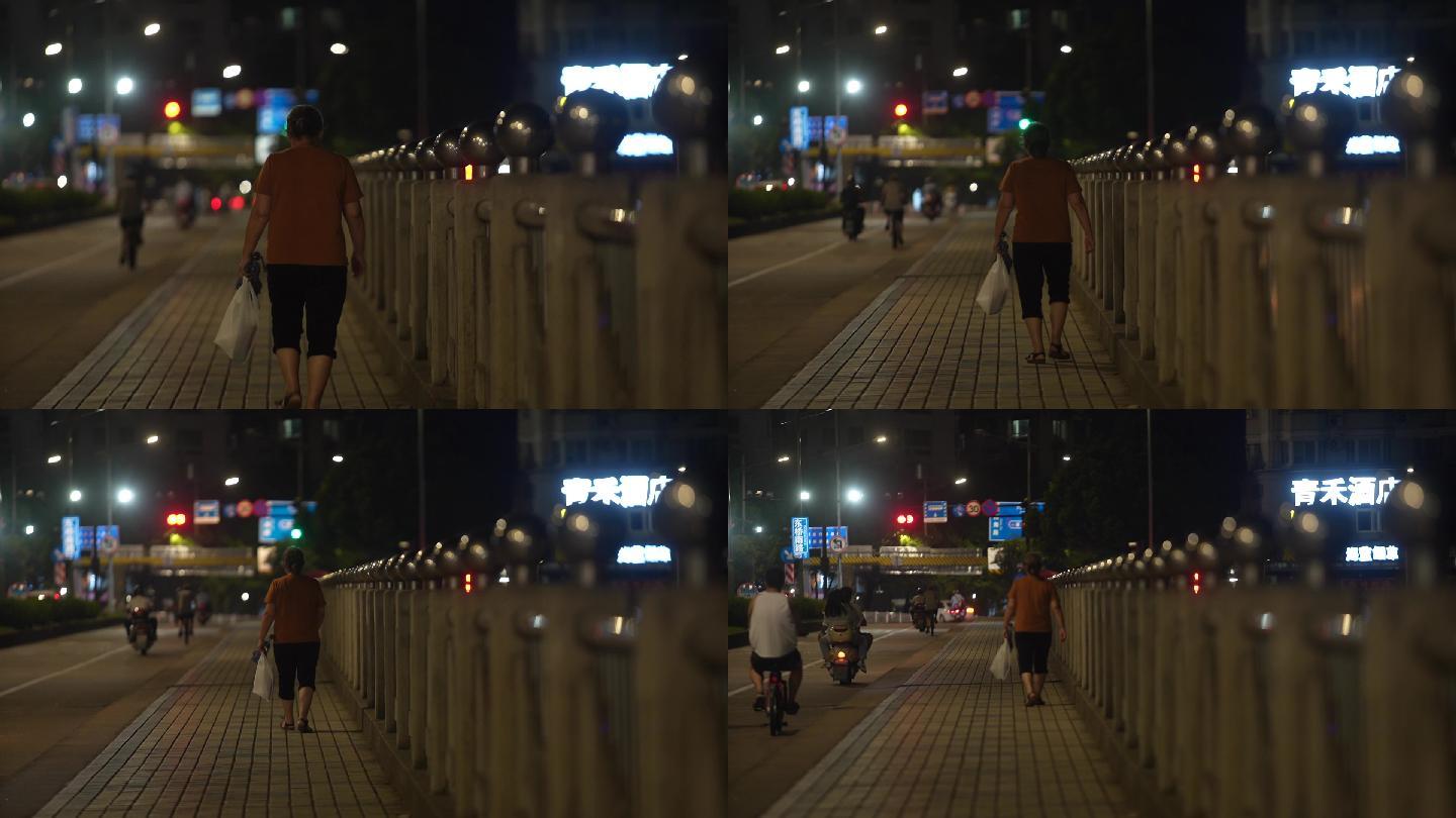 老人孤独的走在路上城市夜景