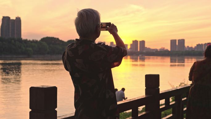 夕阳下拍照的老人背影4K100帧素材