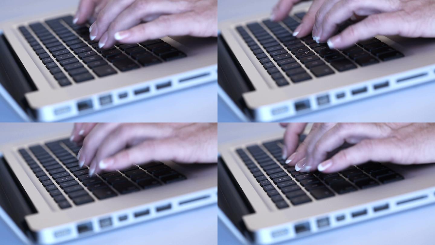轻触银色笔记本电脑的键盘。