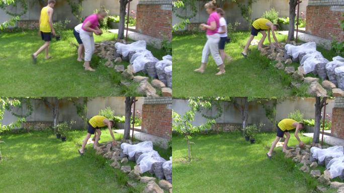 这家人扛着石头建造花坛。
