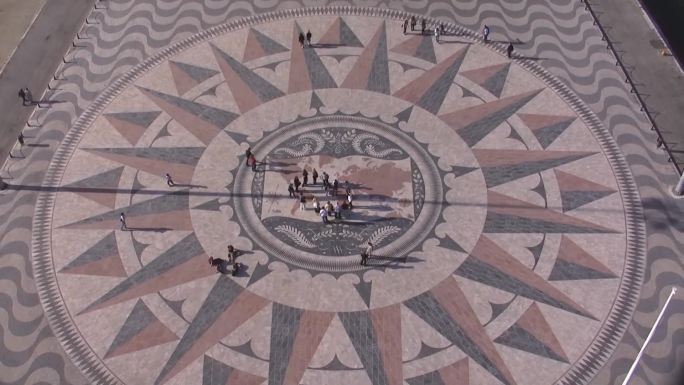 里斯本历史性的石头马赛克广场；它展示了世界地图，并绘制了最重要的发现航程。人们在广场上。