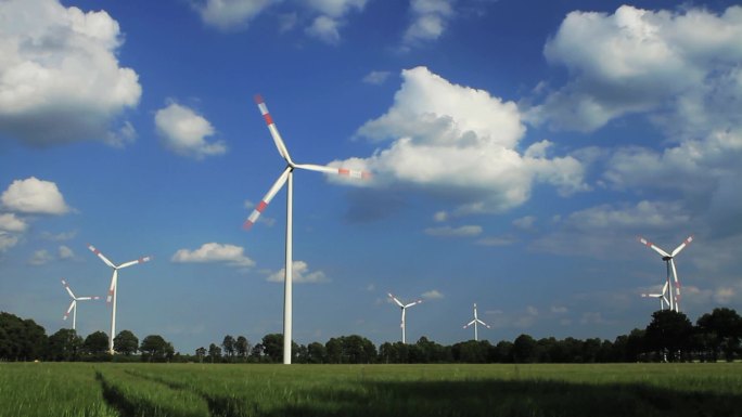 德国下萨克森州蓝天之前的风力涡轮机时间流逝。500%加速度。