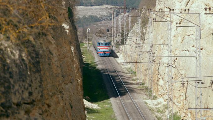 铁路列车在峡谷的公路桥下行驶