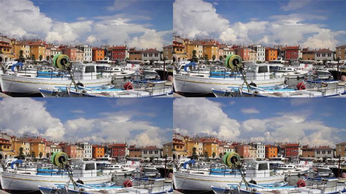 克罗地亚罗维尼市，港口停泊着船只，海边的房屋，时隐时现的云朵