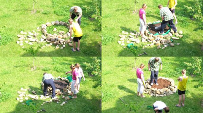 这家人扛着石头建造花坛。