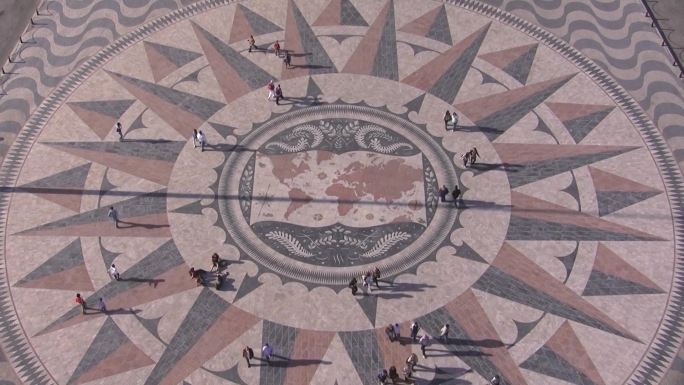 里斯本历史性的石头马赛克广场；它代表了世界地图和最重要的发现航程。人们在广场上。