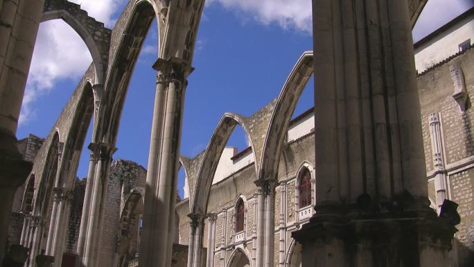 华丽的拱门，一座古老大教堂的石门；背景是大教堂的建筑；白云在蓝天上飘动。