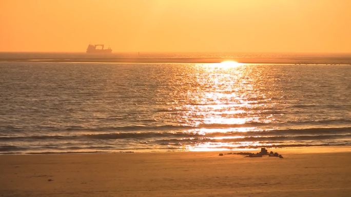 沙滩上的日落，地平线上的船