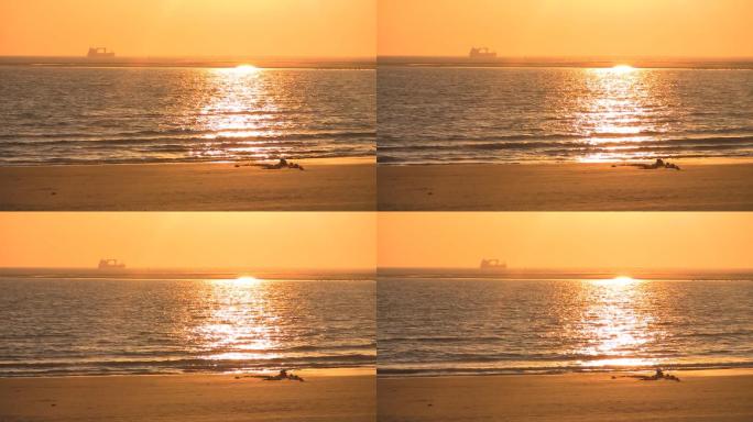 沙滩上的日落，地平线上的船