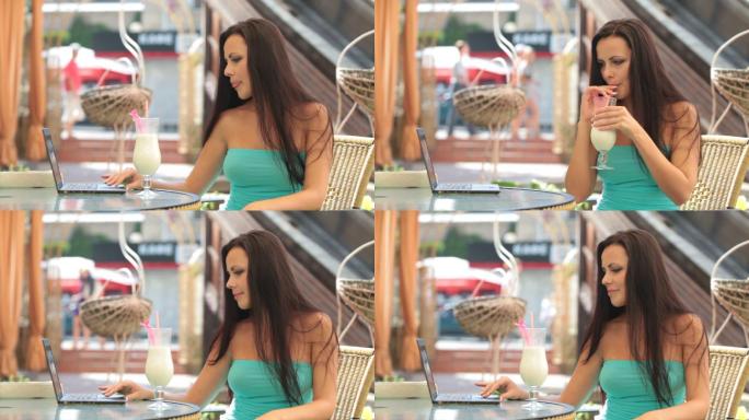 年轻女子在室外咖啡厅使用笔记本电脑